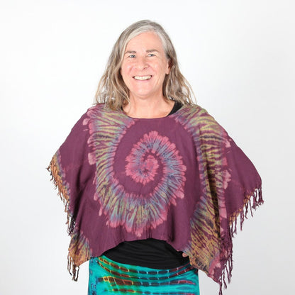 Styled appearance of the Luxury Tie Dye Cropped Poncho worn over trendy high-waisted jeans, demonstrating its versatile fit for UK dress sizes 8-16.