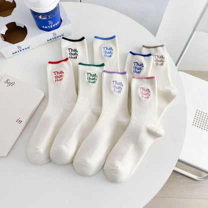 Top view of an array of Elegant White Embroidered Socks for Women showcasing Unique Japanese-Style Font Design on an elegant table.
