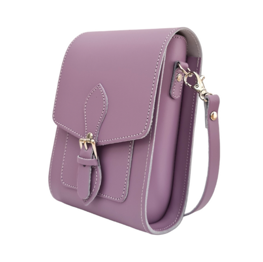 Handmade pastel violet leather festival phone bag with adjustable strap and magnetic closure showcased on a stylish surface, embodying luxury and functionality.
