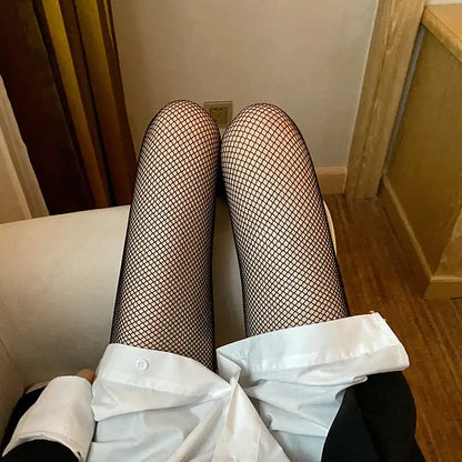 Women’s Luxury Fishnet Design Tights in classic black, accessorised with a stylish shirt, ideal for making a fashionable statement in versatile wear.