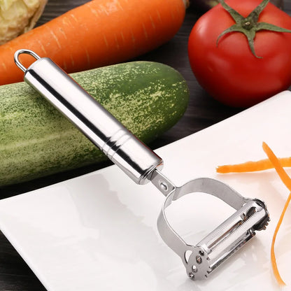 Precision Julienne Stainless Steel Peeler featuring a sleek design, surrounded by fresh vegetables including a cucumber, carrot, and tomato, highlighting its effortless slicing capability.