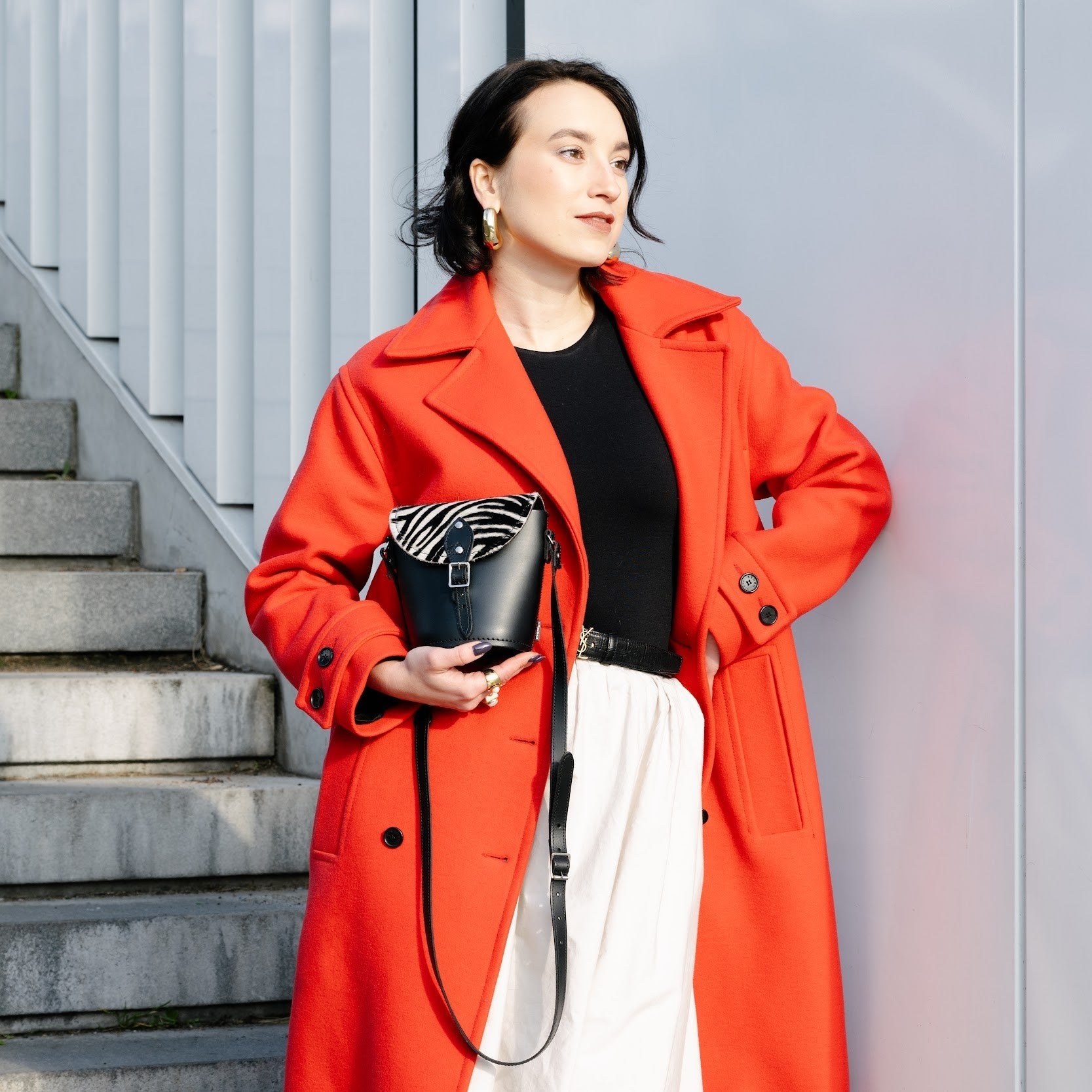 Stylish zebra print leather barrel bag worn crossbody, illustrating versatility and fashionable appeal in everyday wear.