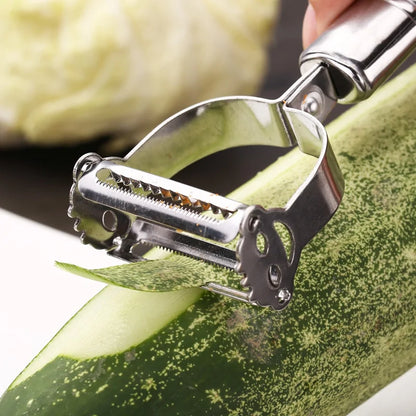 Sophisticated close-up of the Precision Julienne Stainless Steel Peeler gliding across a green zucchini, illustrating its sharp blades and stylish craftsmanship.